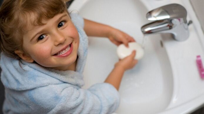 el niño se lava las manos con jabón para prevenir las lombrices